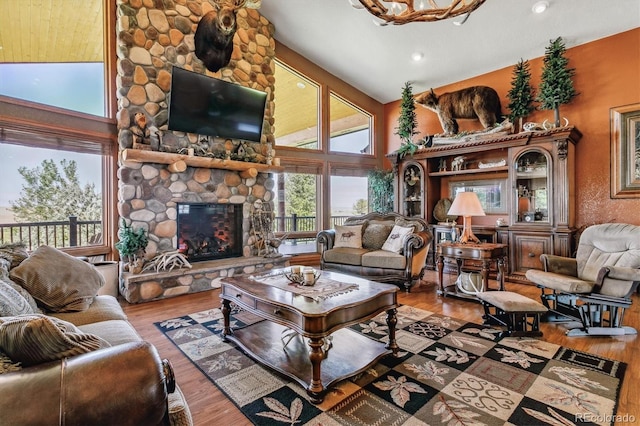 living room featuring a fireplace, high vaulted ceiling, and wood-type flooring