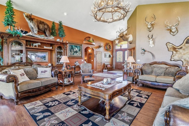 living room with a chandelier, dark hardwood / wood-style floors, and high vaulted ceiling