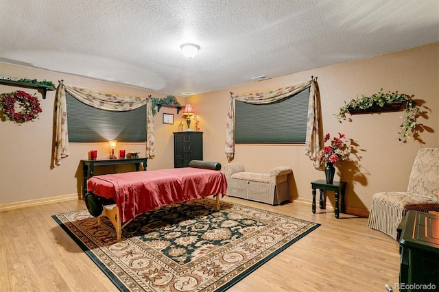 bedroom with wood-type flooring, a textured ceiling, and billiards