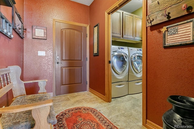 laundry room featuring separate washer and dryer and cabinets