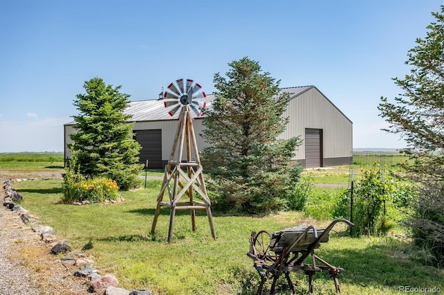 view of yard with a rural view, a garage, and an outdoor structure