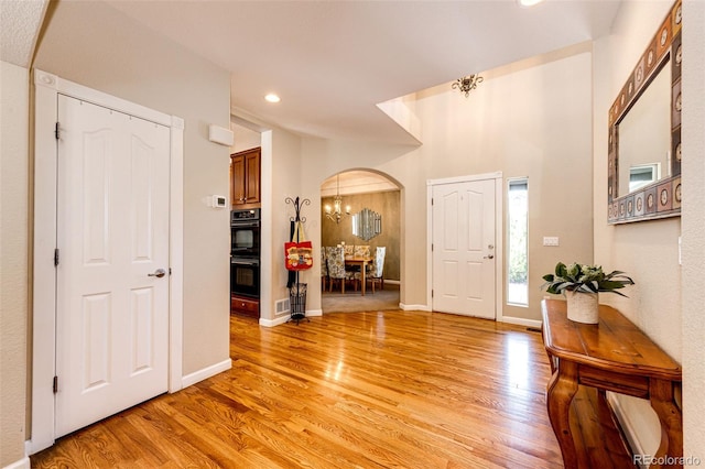24036 E Kettle Pl, Aurora, CO 80016 - foyer featuring arched walkways, light wood finished floors, recessed lighting, and a chandelier