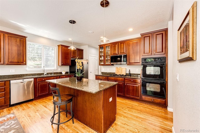 24036 E Kettle Pl, Aurora, CO 80016 - kitchen with appliances with stainless steel finishes, light wood-style flooring, a center island, pendant lighting, and recessed lighting