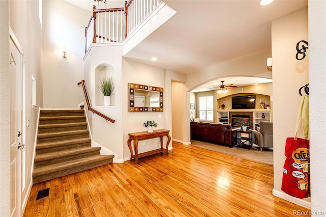 24036 E Kettle Pl, Aurora, CO 80016 - entryway featuring a fireplace, arched walkways, wood finished floors, stairway, and recessed lighting