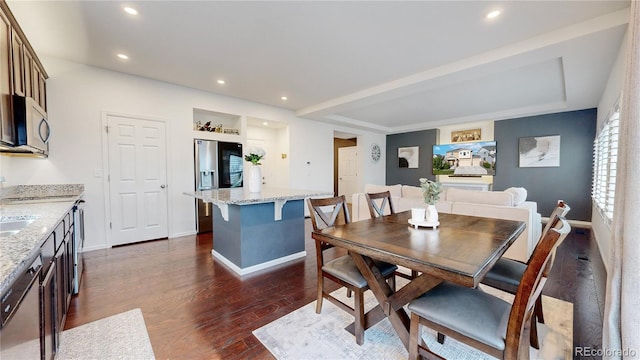 dining area featuring baseboards, dark wood finished floors, and recessed lighting