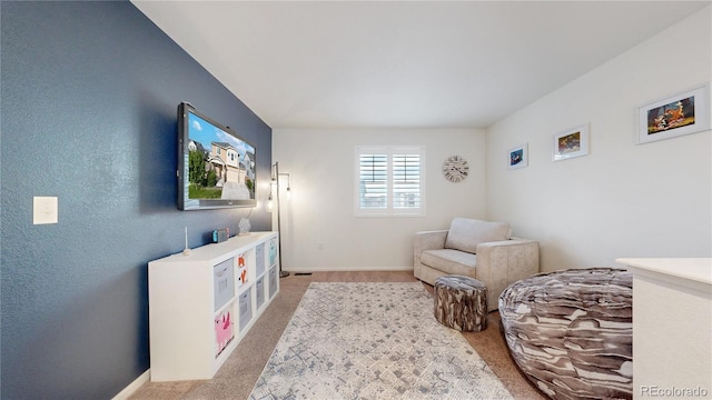 sitting room with light colored carpet and baseboards