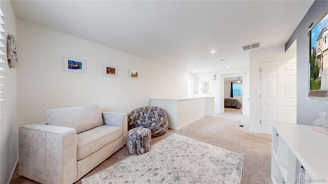 living area with light carpet, visible vents, and recessed lighting