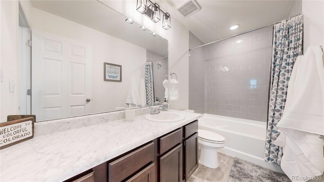 bathroom featuring visible vents, vanity, toilet, and shower / bath combo with shower curtain