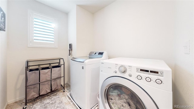 clothes washing area featuring laundry area, baseboards, and separate washer and dryer