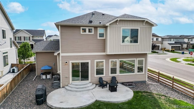 rear view of house with roof with shingles, a patio, entry steps, a residential view, and a fenced backyard