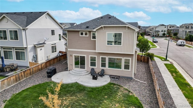 back of property featuring a residential view, a patio area, a yard, and a fenced backyard