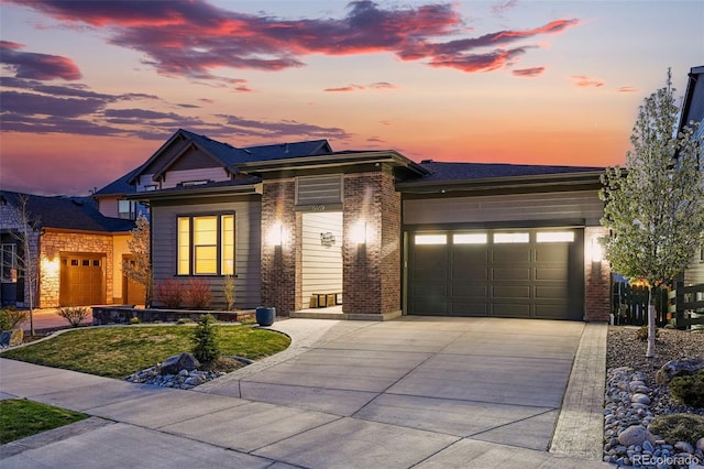 prairie-style house with a garage, brick siding, and concrete driveway