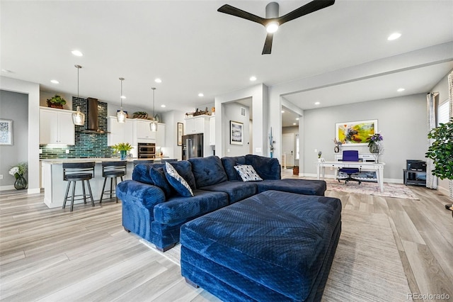 living area with recessed lighting, light wood-style floors, and ceiling fan