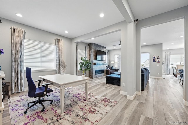 office with a tiled fireplace, baseboards, recessed lighting, and light wood-type flooring