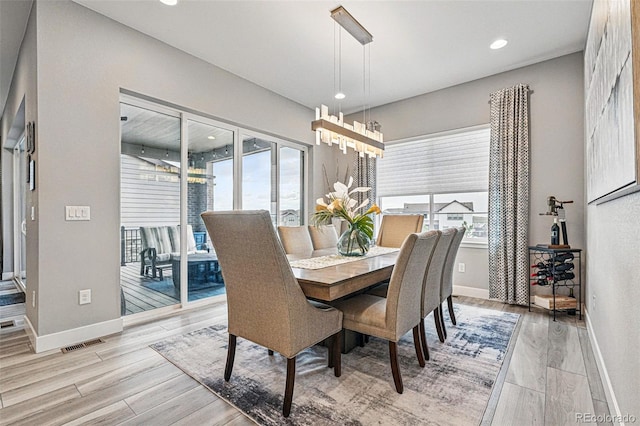 dining area with baseboards and light wood-style floors