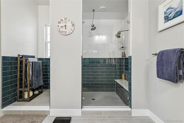 full bathroom featuring baseboards, tile patterned flooring, and tiled shower