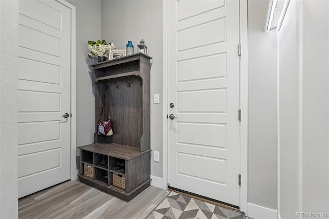 mudroom featuring baseboards and light wood-style floors