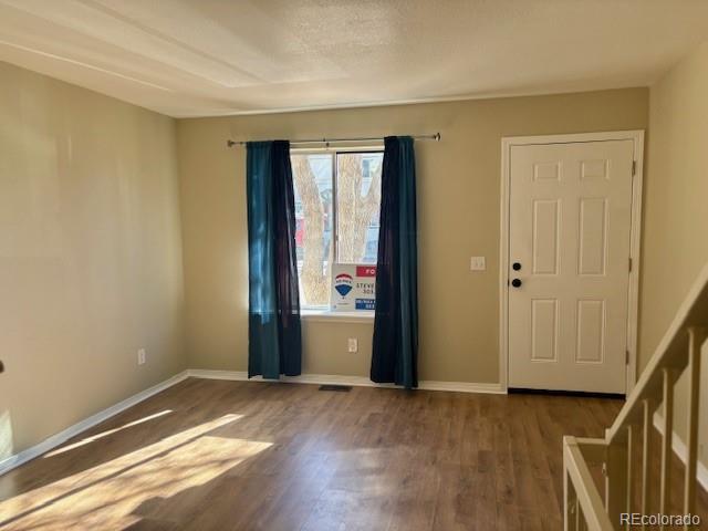 interior space with baseboards and wood finished floors