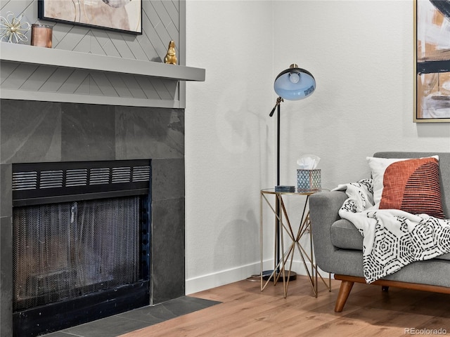 detailed view of a fireplace with flush hearth, wood finished floors, and baseboards