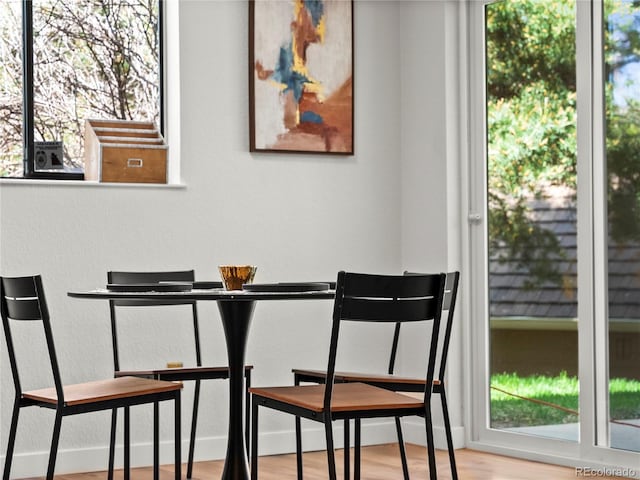 dining space featuring wood finished floors and baseboards