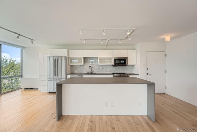 3100 E Cherry Creek S Drive 404, Denver, CO 80209 - kitchen with appliances with stainless steel finishes, a sink, modern cabinets, white cabinets, and rail lighting