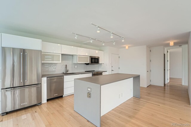 3100 E Cherry Creek S Drive 404, Denver, CO 80209 - kitchen featuring stainless steel appliances, a sink, white cabinets, modern cabinets, and light wood-type flooring