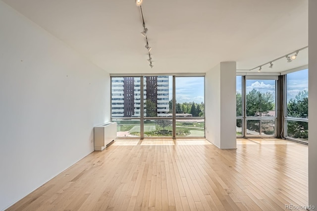 3100 E Cherry Creek S Drive 404, Denver, CO 80209 - spare room with rail lighting, wood-type flooring, and a wall of windows