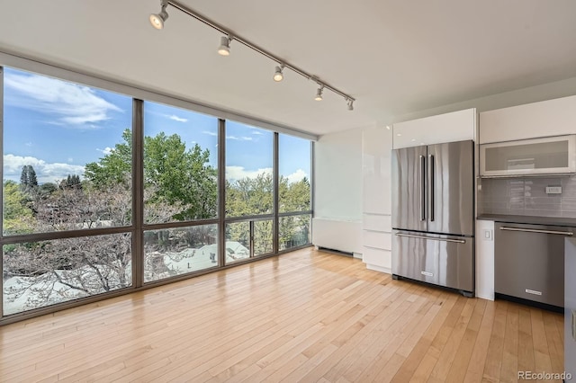 3100 E Cherry Creek S Drive 404, Denver, CO 80209 - kitchen featuring appliances with stainless steel finishes, white cabinetry, modern cabinets, track lighting, and a wall of windows
