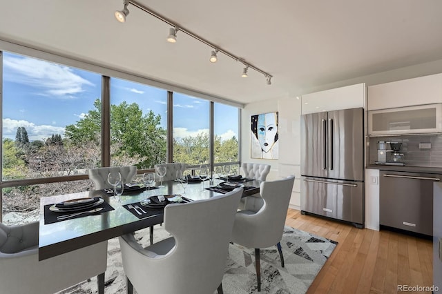3100 E Cherry Creek S Drive 404, Denver, CO 80209 - dining space with light wood-style flooring and rail lighting