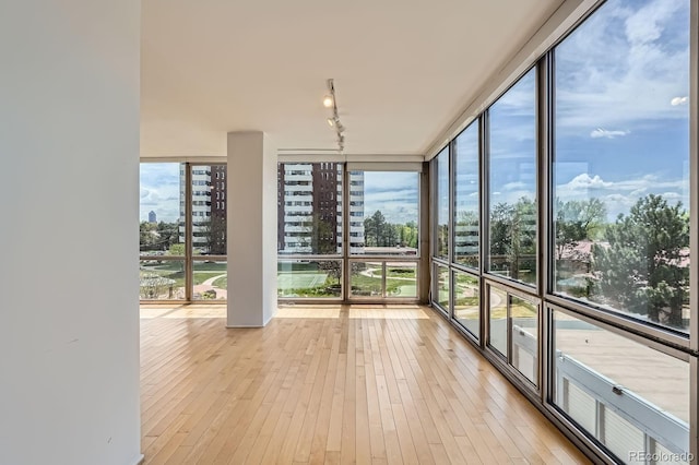 3100 E Cherry Creek S Drive 404, Denver, CO 80209 - unfurnished sunroom featuring a wall of windows, track lighting, and hardwood / wood-style flooring