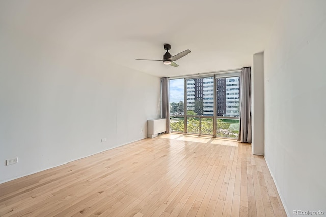 3100 E Cherry Creek S Drive 404, Denver, CO 80209 - spare room featuring a wall of windows, a ceiling fan, and hardwood / wood-style floors