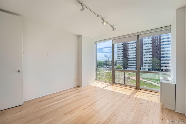 3100 E Cherry Creek S Drive 404, Denver, CO 80209 - spare room featuring rail lighting, wood-type flooring, and expansive windows