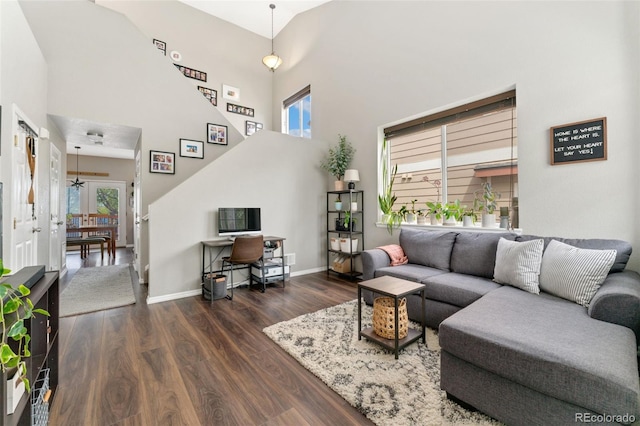 10475 E Abilene St, Commerce City, CO 80022 - living room featuring dark wood-style flooring, a towering ceiling, and baseboards