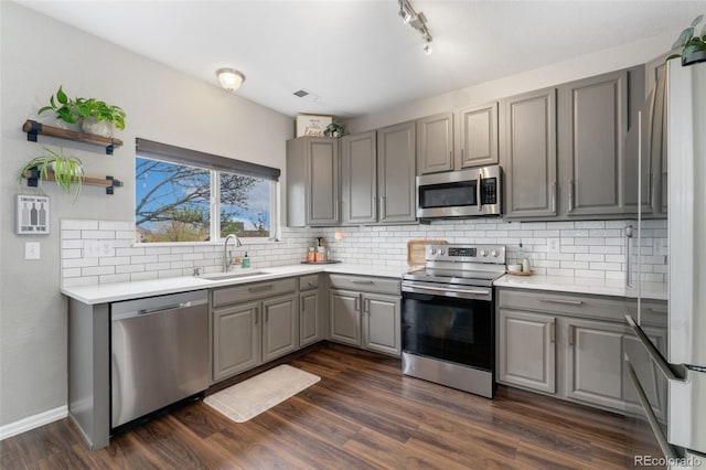 10475 E Abilene St, Commerce City, CO 80022 - kitchen with stainless steel appliances, gray cabinets, a sink, backsplash, and light countertops