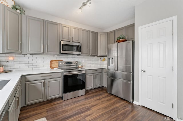 10475 E Abilene St, Commerce City, CO 80022 - kitchen featuring stainless steel appliances, gray cabinets, dark wood finished floors, backsplash, and light countertops
