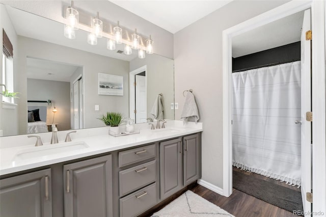 10475 E Abilene St, Commerce City, CO 80022 - full bath featuring connected bathroom, wood finished floors, double vanity, and baseboards