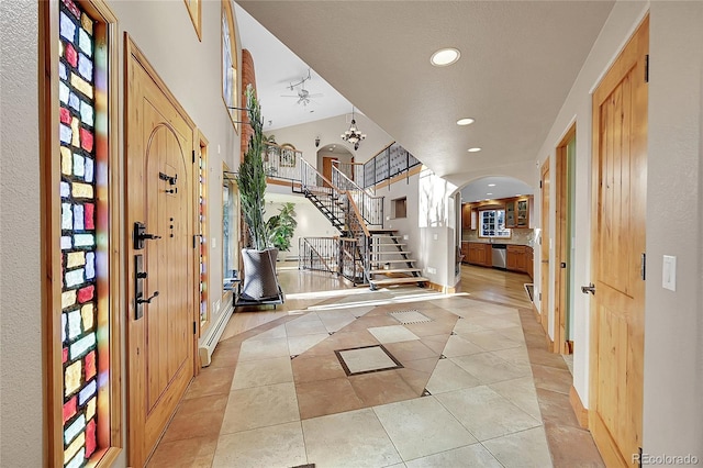 entrance foyer with ceiling fan, light tile patterned floors, and vaulted ceiling