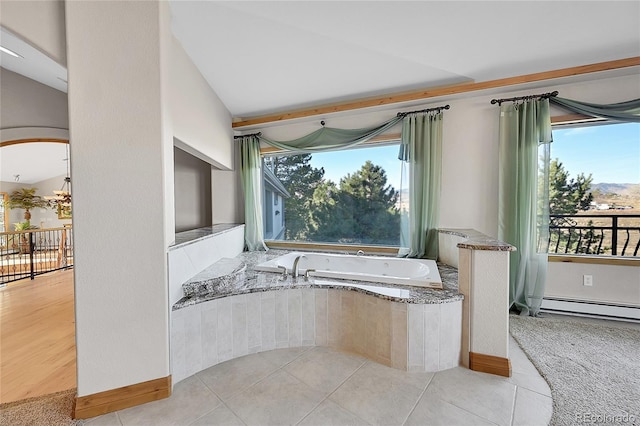 bathroom featuring a relaxing tiled tub, a baseboard radiator, tile patterned floors, and vaulted ceiling