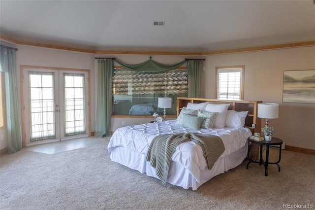 bedroom with access to outside, light colored carpet, and french doors