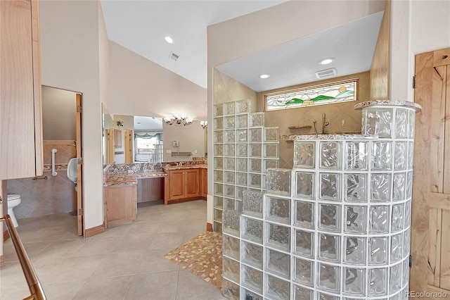 bathroom with vanity, vaulted ceiling, tile patterned floors, toilet, and walk in shower