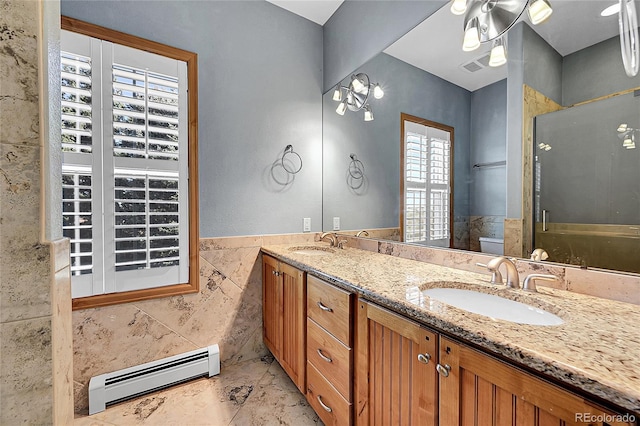 bathroom with tile walls, vanity, a baseboard radiator, toilet, and walk in shower