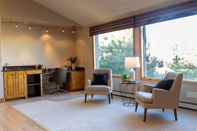 home office featuring vaulted ceiling, baseboard heating, and light hardwood / wood-style floors