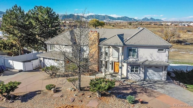 view of front of home with a tiled roof, driveway, a mountain view, and stucco siding