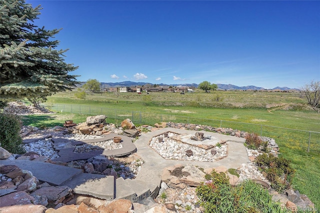 view of yard featuring a mountain view, fence, and a rural view