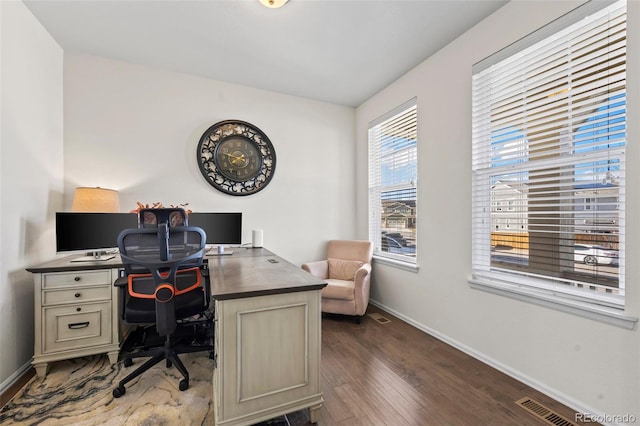 home office with dark wood-type flooring, baseboards, and visible vents