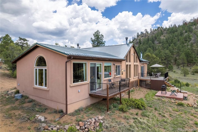 1111 Red Feather Rd, Cotopaxi, CO 81223 - back of property featuring a deck, metal roof, a patio, and stucco siding