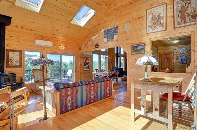 1111 Red Feather Rd, Cotopaxi, CO 81223 - dining space with a wood stove, wooden walls, a skylight, wood finished floors, and high vaulted ceiling