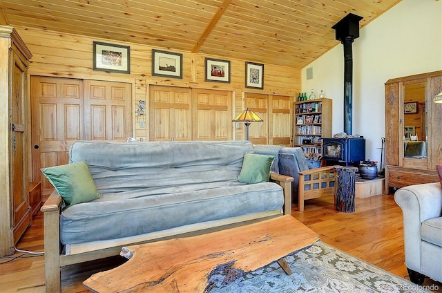 1111 Red Feather Rd, Cotopaxi, CO 81223 - living room featuring a wood stove, vaulted ceiling, light wood-type flooring, wooden ceiling, and wooden walls