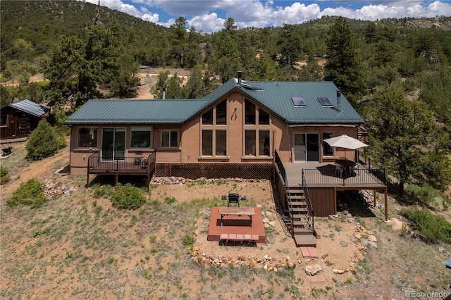 1111 Red Feather Rd, Cotopaxi, CO 81223 - back of house featuring stairs, a deck, a forest view, and metal roof