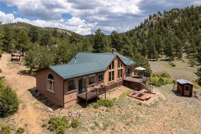 1111 Red Feather Rd, Cotopaxi, CO 81223 - back of property featuring a wooden deck, metal roof, a view of trees, and stairway